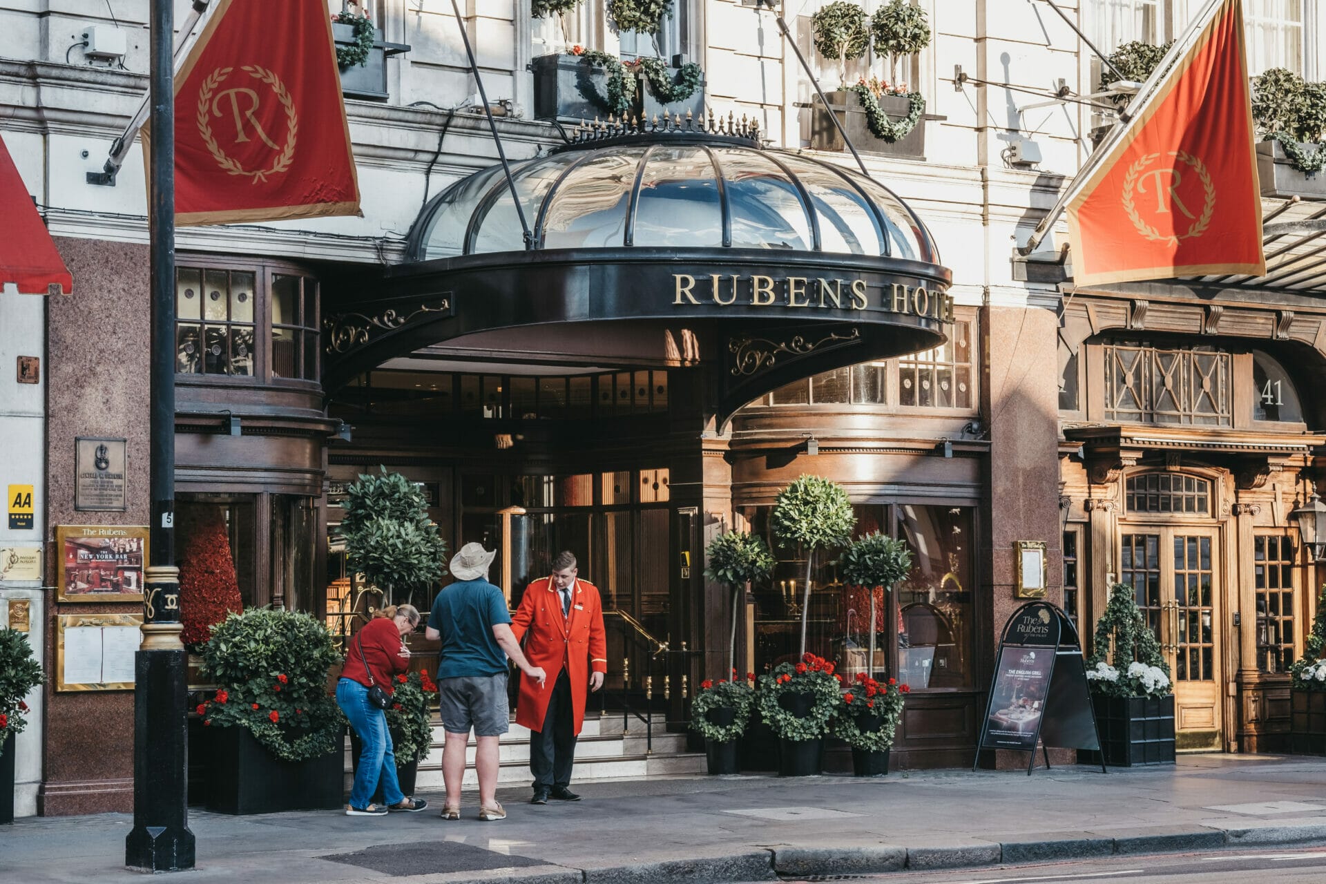London, UK - July 15, 2019: People talking to butler outside The Rubens at the Palace, a 5 star hotel located in central London with views across the Royal Mews at Buckingham Palace.